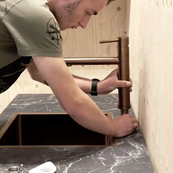 Een student van het Hout en Meubileringscollege die een kraam monteert.