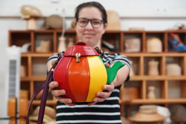 Student met eindwerkstuk: tas in de vorm van theepot