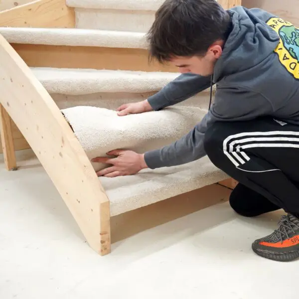 Een student van het Hout en Meubileringscollege stoffeert een trap
