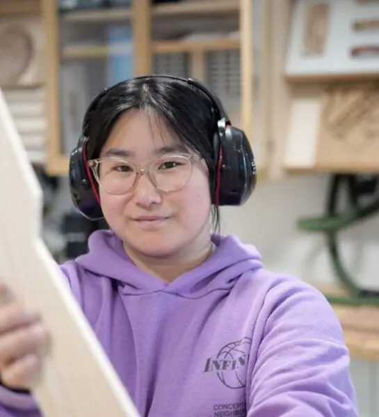 Student heeft hout vast en gehoorbescherming op
