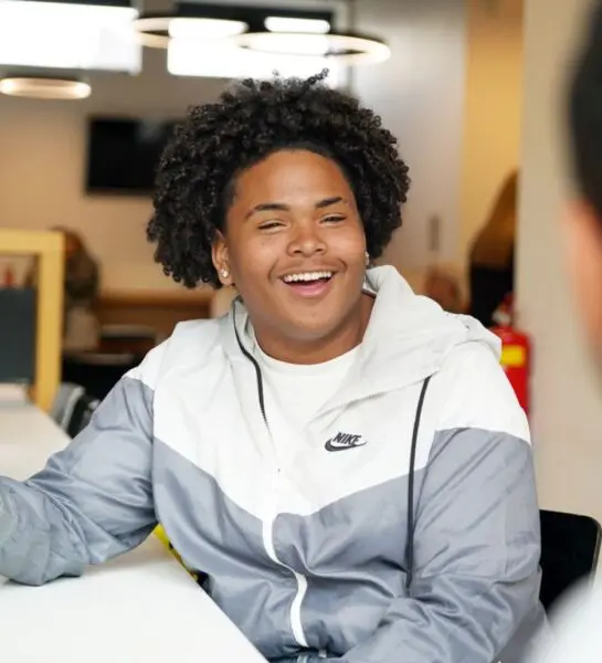 Student kijkt lachend in de camera
