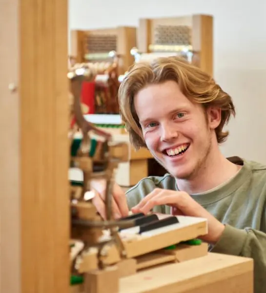 Student bespeelt toetsen en lacht in de camera